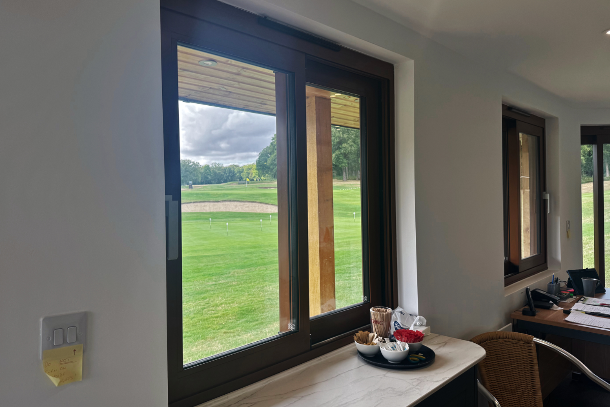 Sliding window from the inside of the golf hut looking onto golf course